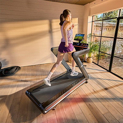 Model running on adidas T-700 Treadmill beside large windows 