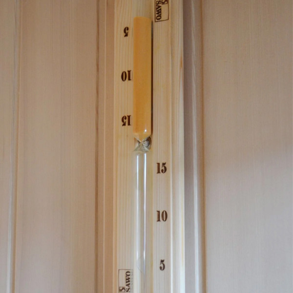 Close-up of a 15-minute wooden sauna sand timer inside the Snug sauna.