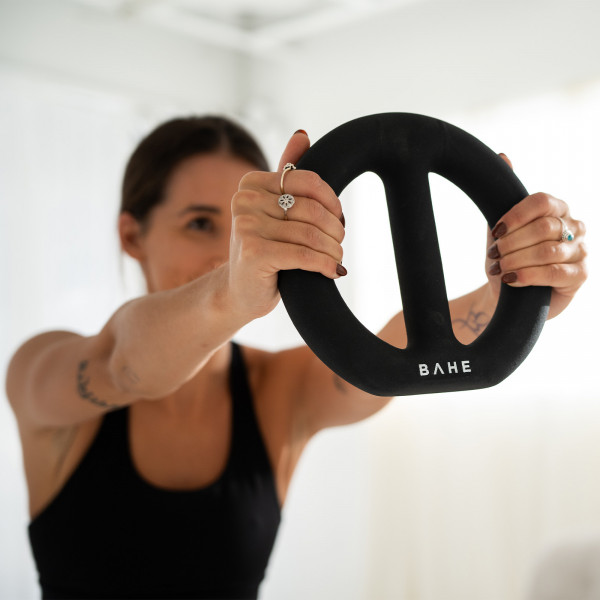 A lifestyle image of the BAHE Halo Weight (4kg) being held out by a model.