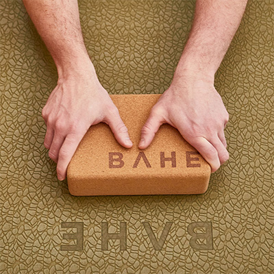 Lifestyle image of the BAHE Cork Yoga Block in the hands of a model