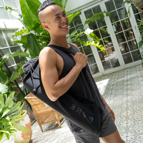 Lifestyle image of the BAHE Essential Yoga mat bag being worn by a model