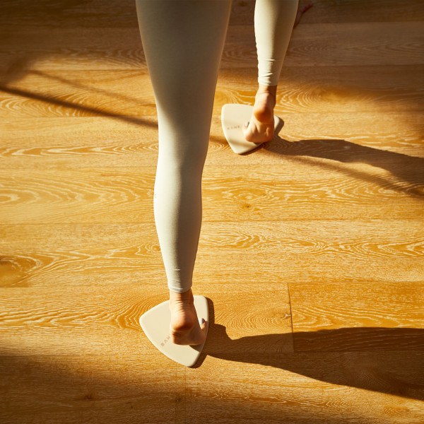 Model using the BAHE Flow Sliders for a sliding lunge exercise.
