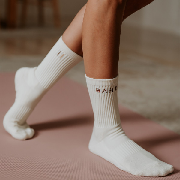 Lifestyle image of the BAHE Studio Grippy Crew Socks being worn on a mat