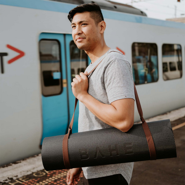 Model posing with the BAHE Prime Support 6mm Mat rolled up into the carry sling