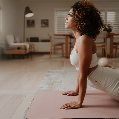 Model performing a yoga stretch on the BAHE Soft Touch 5mm Mat