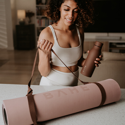 Image of a model holding the mat strap and a water bottle