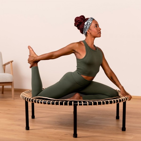 Person using Bellicon Classic Black Trampoline for yoga.