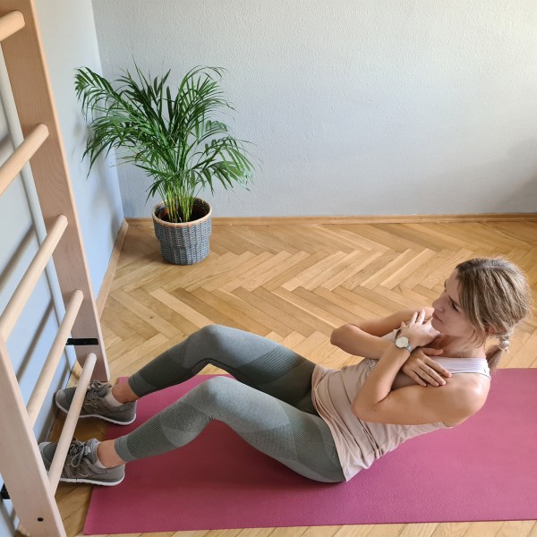 User doing sit-ups using BenchK 100 Wall Bars for support