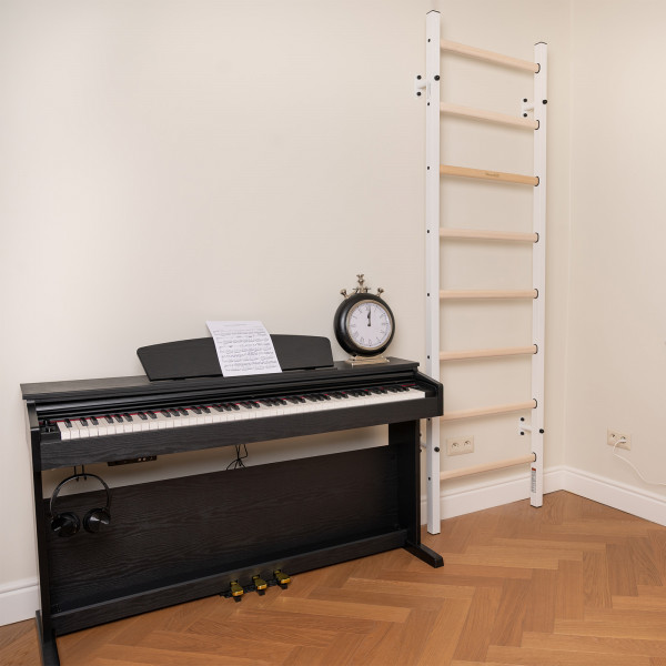 White BenchK 200 Wall Bars installed beside a digital piano