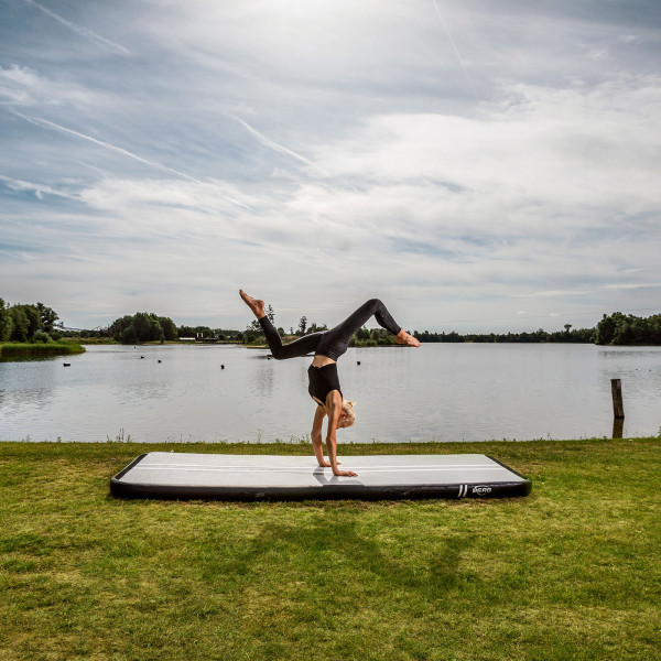 Athlete practising a handstand on BERG AirTrack Home by the lake.