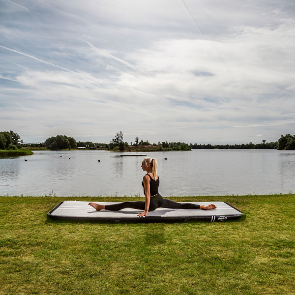 Athlete doing a full split on BERG AirTrack Home by the lake.