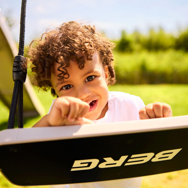 Child holding onto the BERG PlayBase Seat Swing