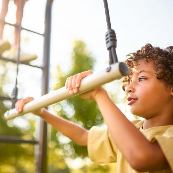 Close-up of child gripping the BERG PlayBase Trapeze bar