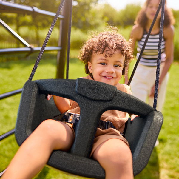 Baby smiling in the BERG PlayBase Baby Swing