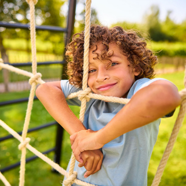 Child leaning into the BERG PlayBase Climbing Net
