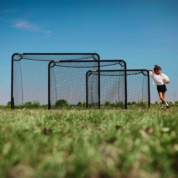 Three BERG SportsGoals in different sizes with a player leaning on the smallest one.