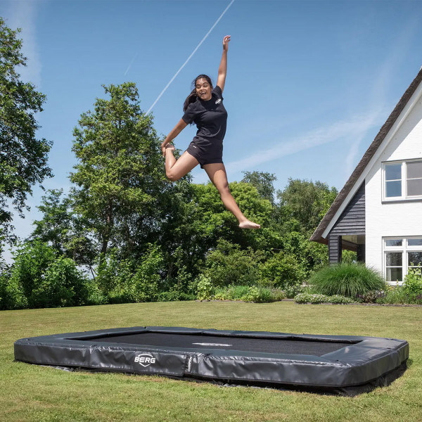 Wide shot of the model jumping on the BERG Sports Ultim Champion InGround Trampoline