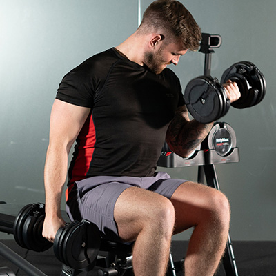 User curling the BodyMax 34 kg Selectabell Adjustable Dumbbell