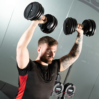 User pressing two BodyMax 34 kg Selectabell Adjustable Dumbbells overhead