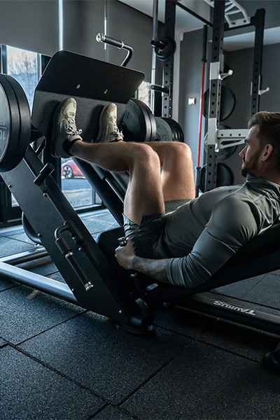 user performing leg press on weight machine with 40mm floor tiles