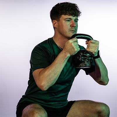 Model goblet squatting with a BodyMax Kettlebone Kettlebell