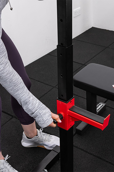 User adjusting height on the BodyMax CF310 Home Squat Stands 