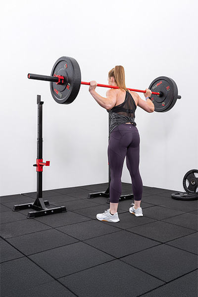 User performing a barbell squat with the BodyMax CF310 Home Squat Stands