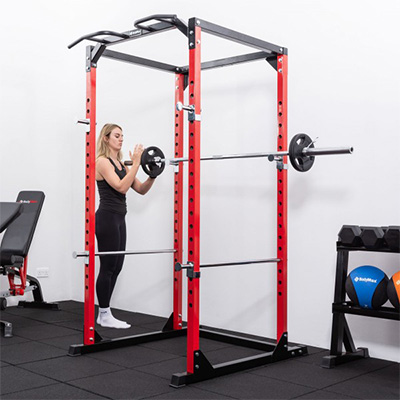 User adjusting bar catchers on the BodyMax CF375 Power Rack