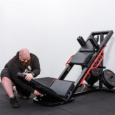 Model adjusting the back pad on the BodyMax CF800 Leg Press / Hack Squat Machine