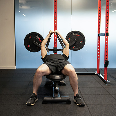 A model performing a pectoral fly with the BodyMax Rack Fly Attachment, the image is at the top of the exercise. 