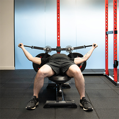 A model performing a pectoral fly with the BodyMax Rack Fly Attachment