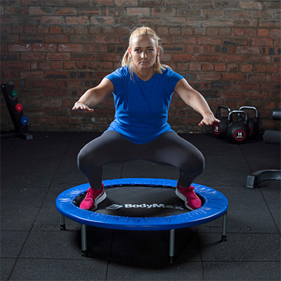 Front view of a user performing a squat on the BodyMax Mini Fitness Trampoline in blue 