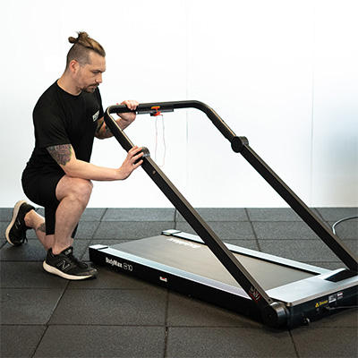 Model unfolding the BodyMax TM10 Walking Pad to switch to treadmill mode