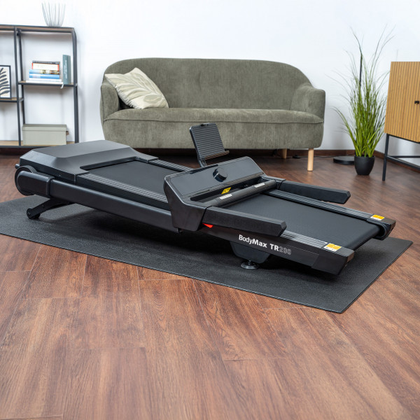 Folded BodyMax TR200 Treadmill positioned in living room