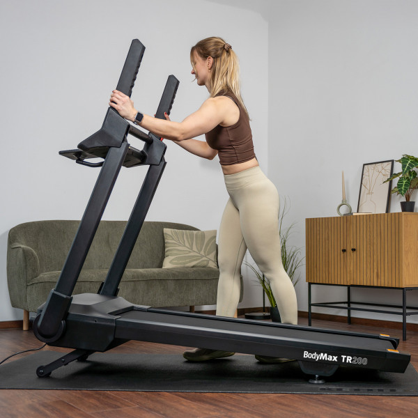 Person unfolding the BodyMax TR200 Treadmill