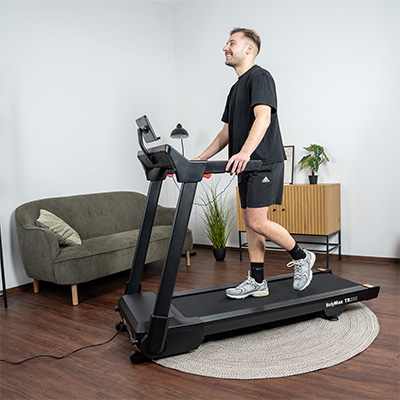 Person walking on the BodyMax TR200 Treadmill in living room