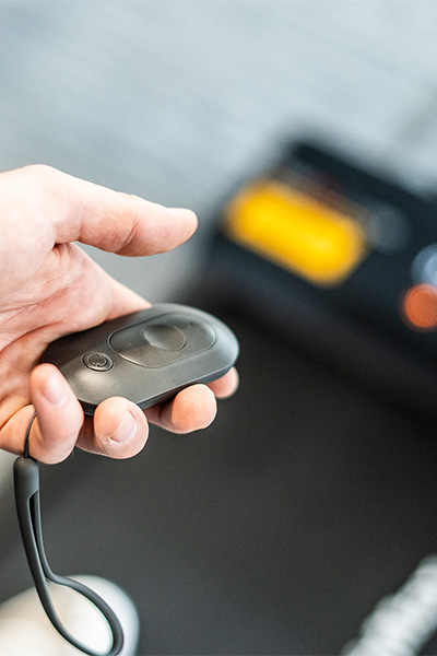 User holding the remote control for the BodyMax WP60 Treadmill