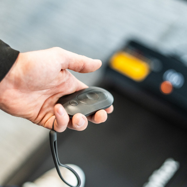 User holding the remote control for the BodyMax WP60 Treadmill