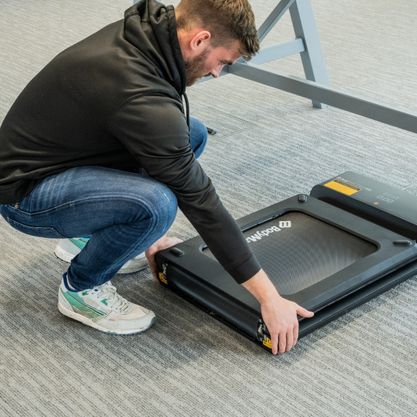 User lowering the BodyMax WP60 Treadmill to unfold it
