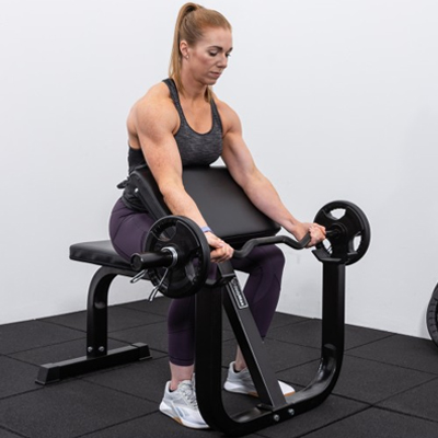 Lifestyle image of a model using the BodyMax CF625 Heavy Duty Preacher Curl Bench