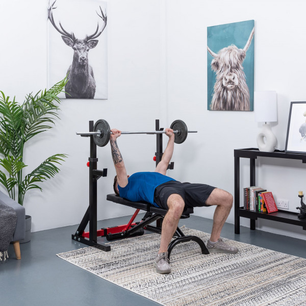 User bench pressing at full extension with the BodyMax CF325 FID Utility Weight Bench