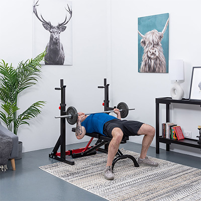 User bench pressing with the BodyMax CF325 FID Utility Weight Bench