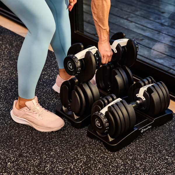 BowFlex 52s Adjustable Dumbbell - Model removing the dumbbell from its cradle