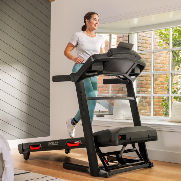 User running on the BowFlex BXT8Ji Folding Treadmill in a bright home setting
