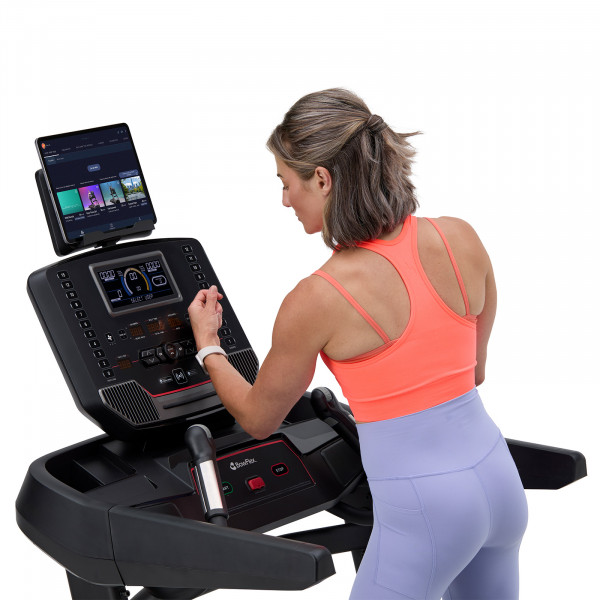 Person tapping the BowFlex T9 treadmill console to sync their Apple Watch.
