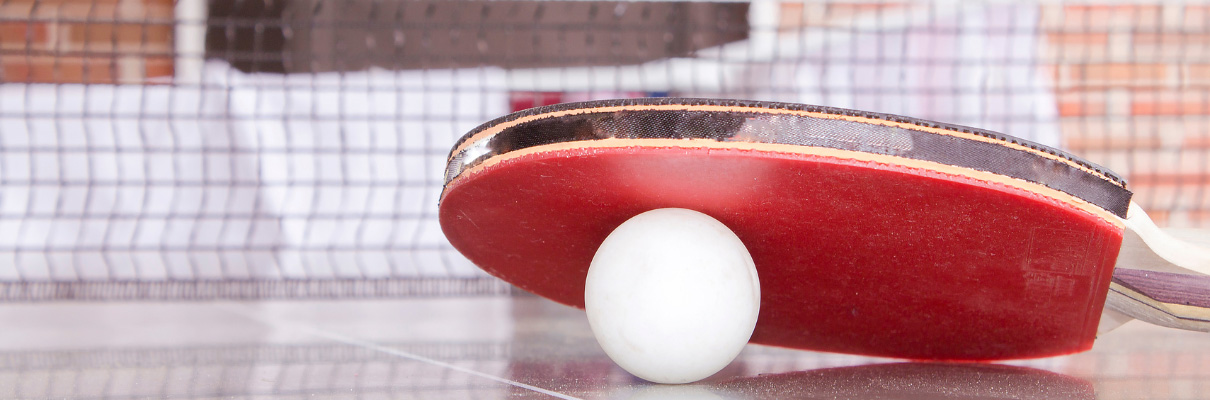 Close-up of a table tennis bat and ball on a table tennis table