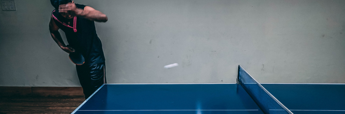 Table tennis player serving during a rally