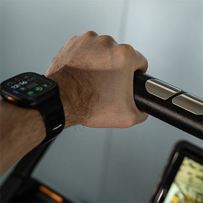 close-up image of a model using the handlebars of the cardiostrong IT70.