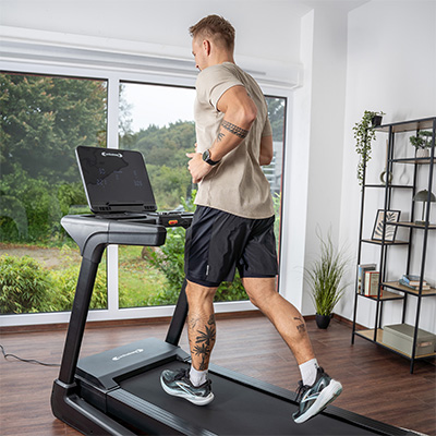 User jogging on the cardiostrong TX30 Treadmill near a window