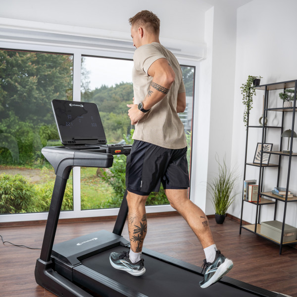 User jogging on the cardiostrong TX30 Treadmill near a window